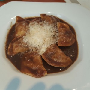 Pasta rellena de asado negro en su salsa con queso parmesano
