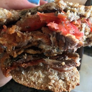 arepa de masa integral con sardinas tomate y tapenade de olivas negras