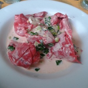 Tortelones de remolacha rellenos de pescado en salsa blanca con ajoporro