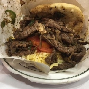 solomo, tomate, aguacate (esta no tenia) y queso amarillo. eso lleva esta arepa.