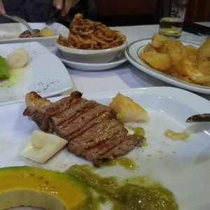solomo a la parrilla, aros de cebolla, yuca frita y aguacate con palmito