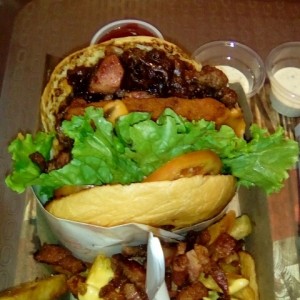 Shack doble con cebolla caramelizada, tocineta, queso cheddar, papas con queso y tocineta