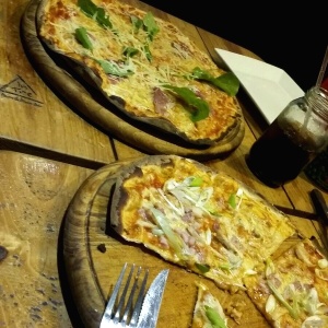 Pizza de la casa y la otra es rugula, parmesano y jamon serrano.