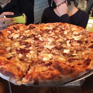 Pizza con tomates secos, queso de cabra y cebollas caramelizadas